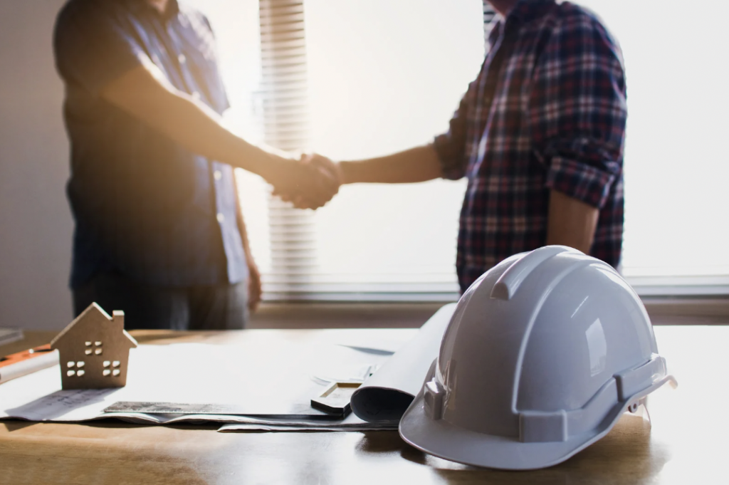 Deux professionnels du monde de la construction se servent la main pour conclure un accord.